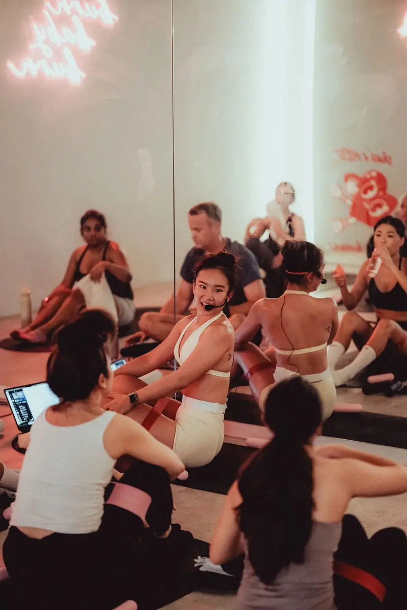 A Hot Mat Pilates class sitting on their mats, laughing
