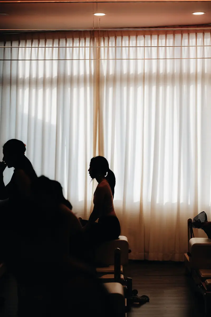 Silhouettes on reformers against white curtains