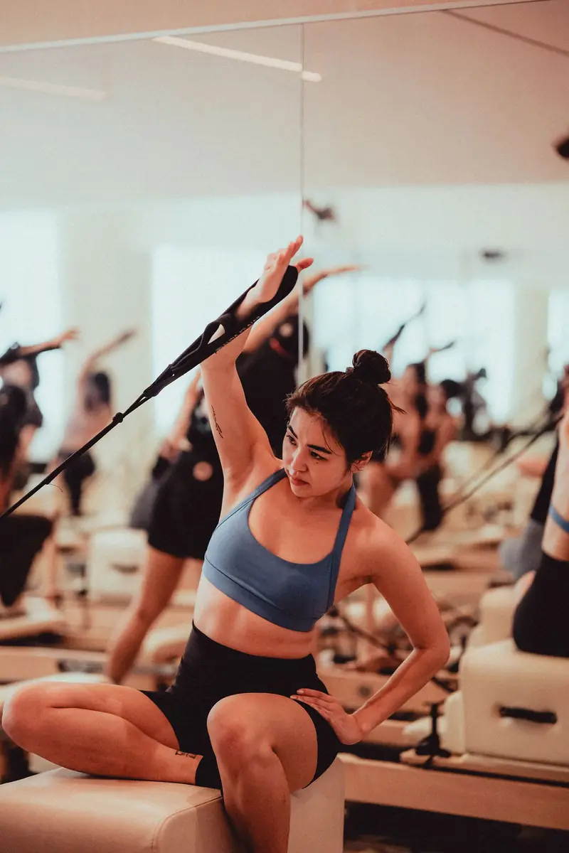 A woman working with the straps on a reformer