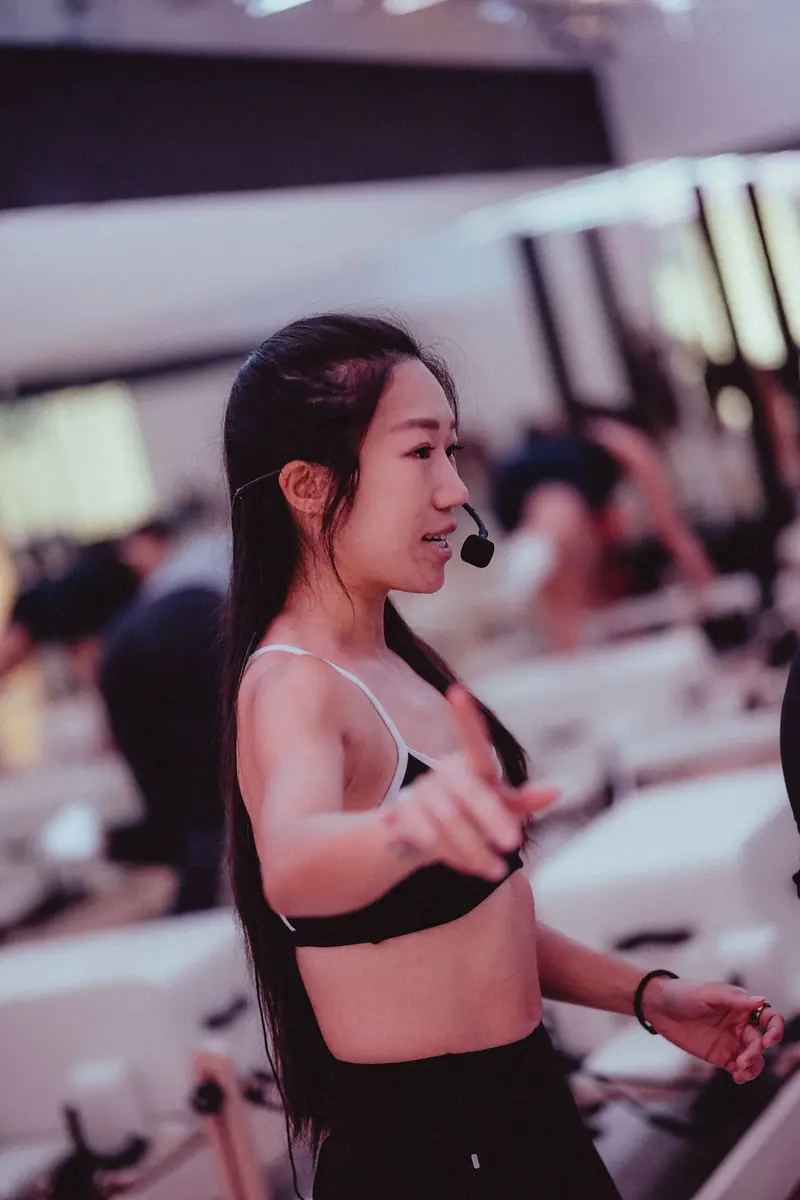 A reformer instructor with a headset