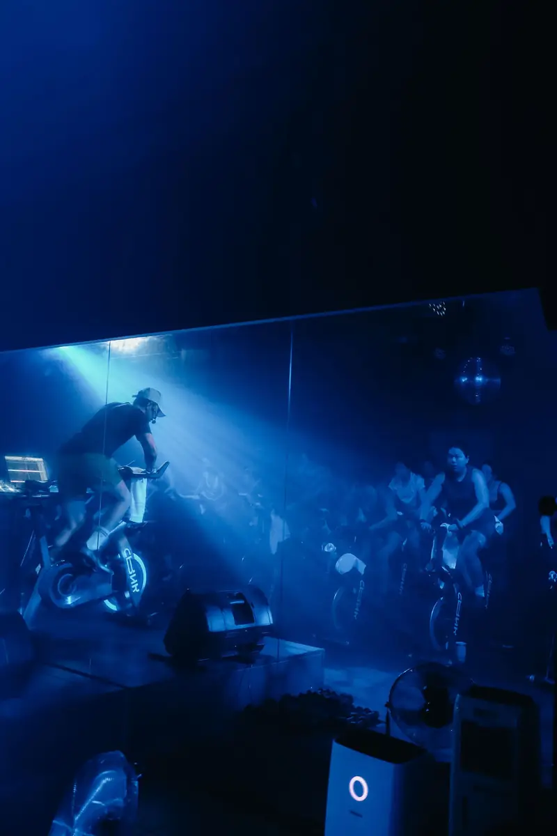 A rider in blue light with beams across the room