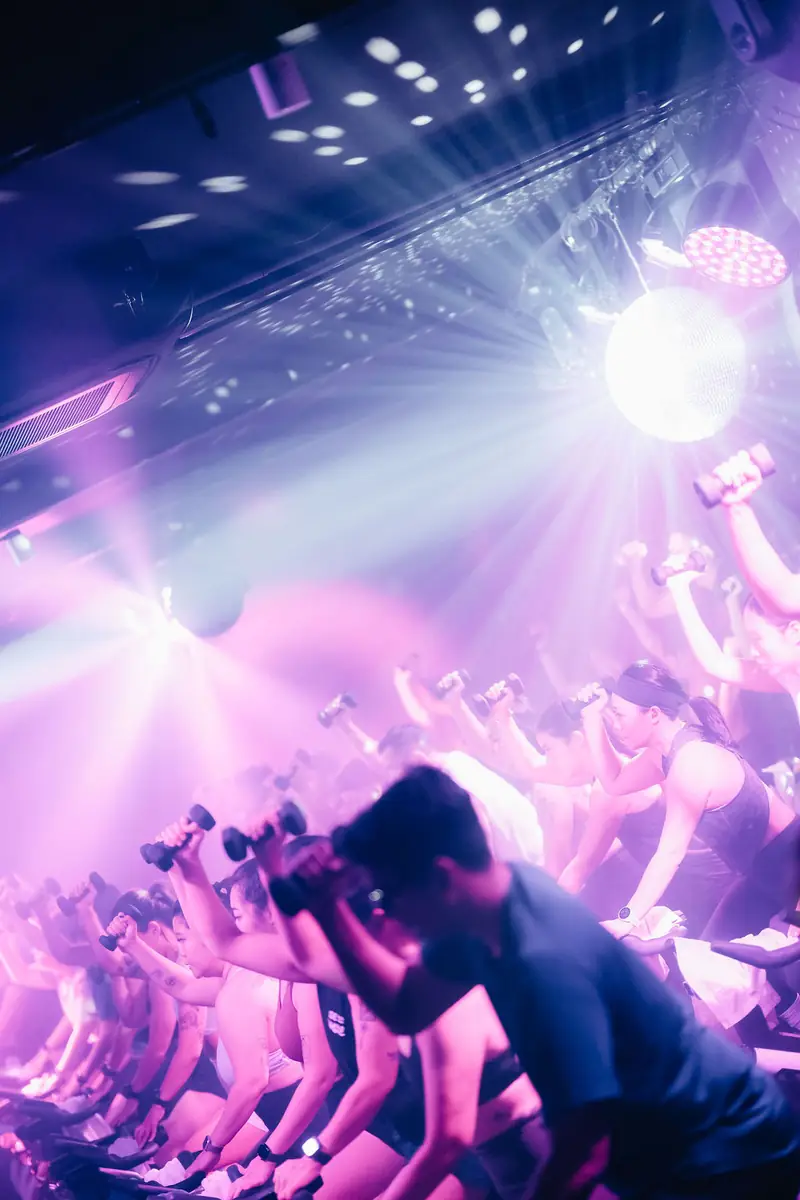 Riders under a burst of purple disco-ball light