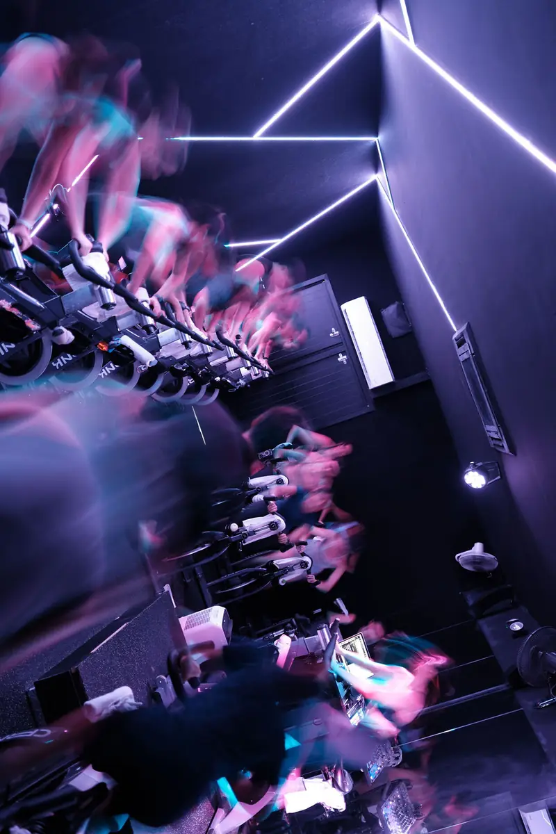 Motion-blurred riders under purple neon lines
