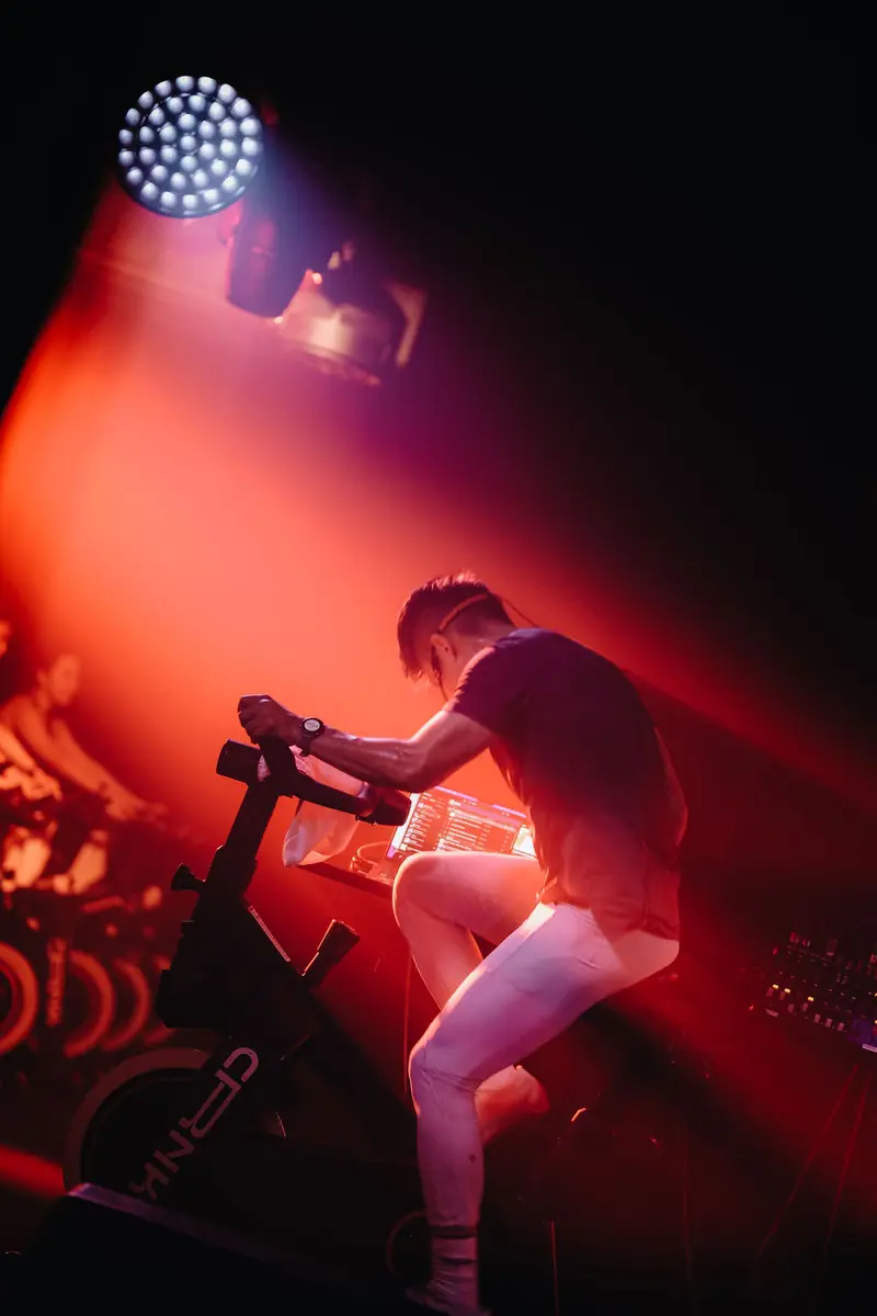 A rider standing on the pedals in red light