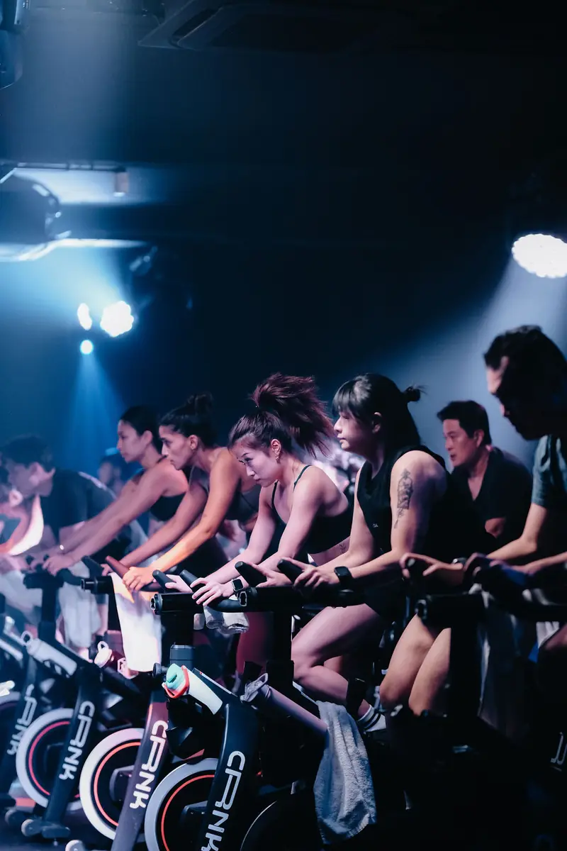 Riders on CRNK bikes in blue light