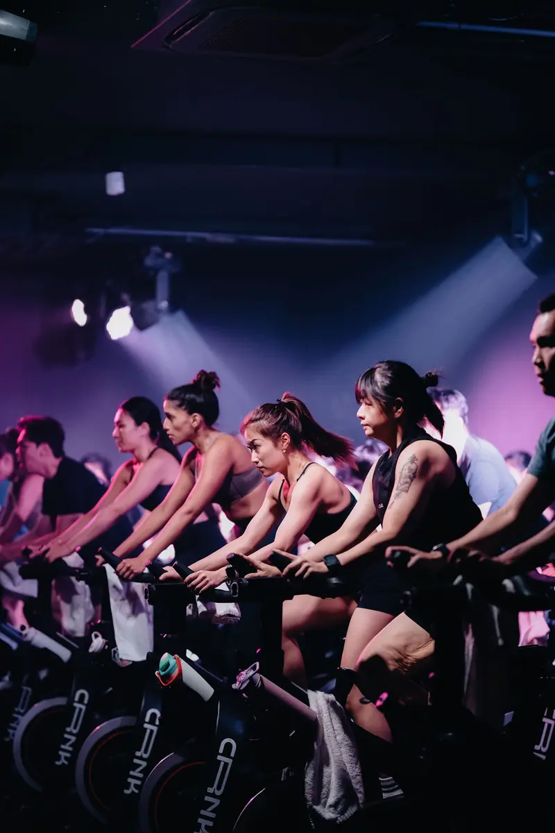 A full row of riders under purple light