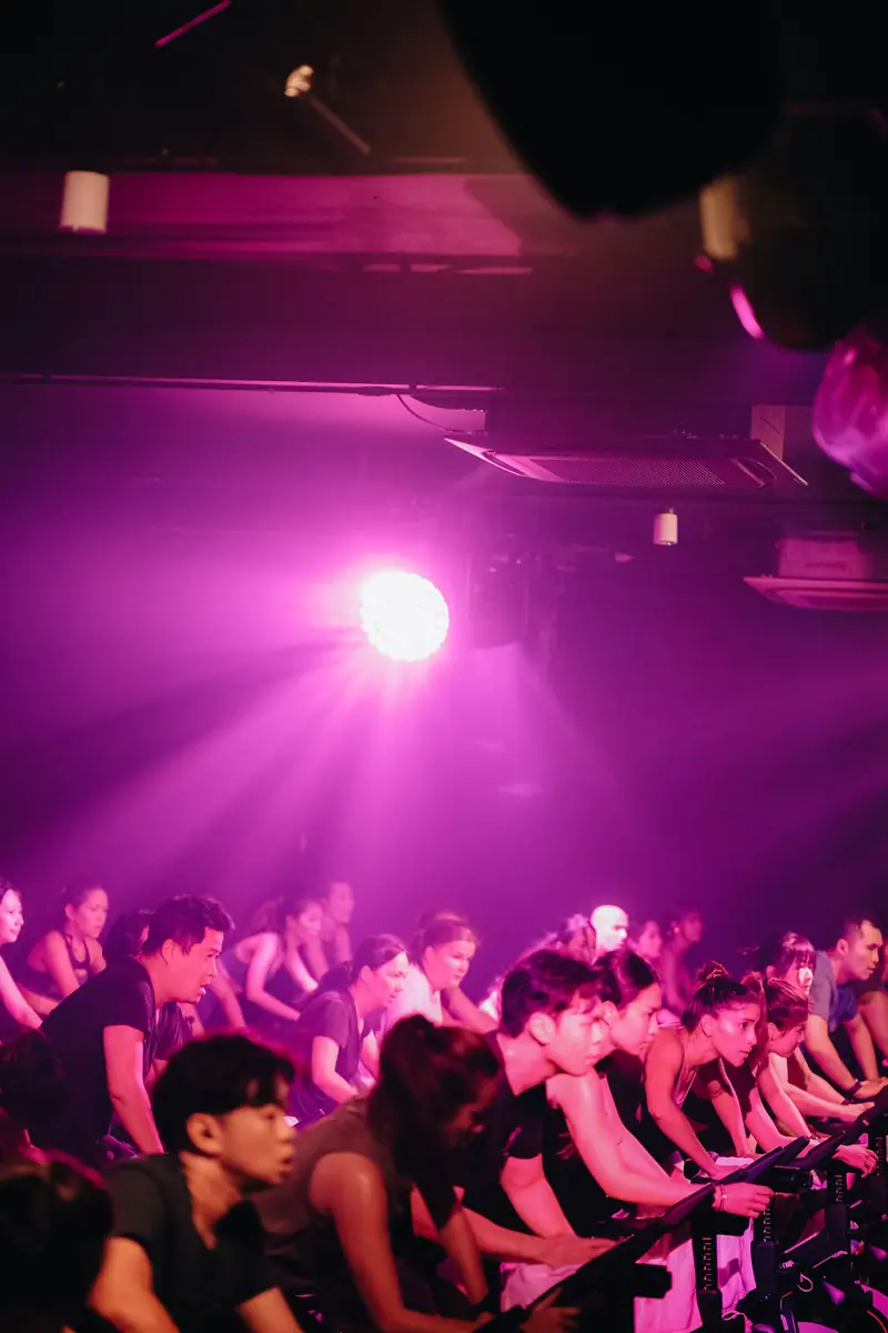 A packed ride room under magenta light