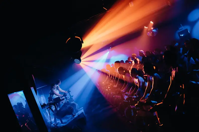 A wide ride room lit by orange and blue beams from above