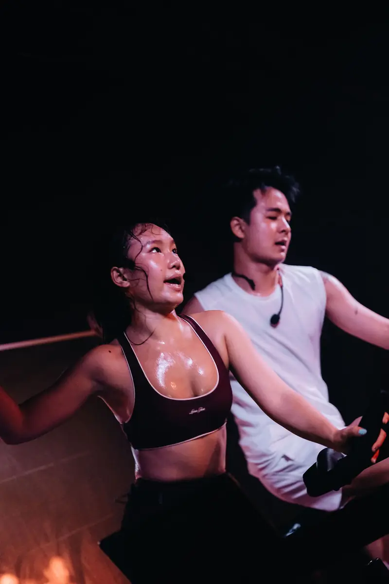 Two riders close up, sweaty, mid-ride in warm light